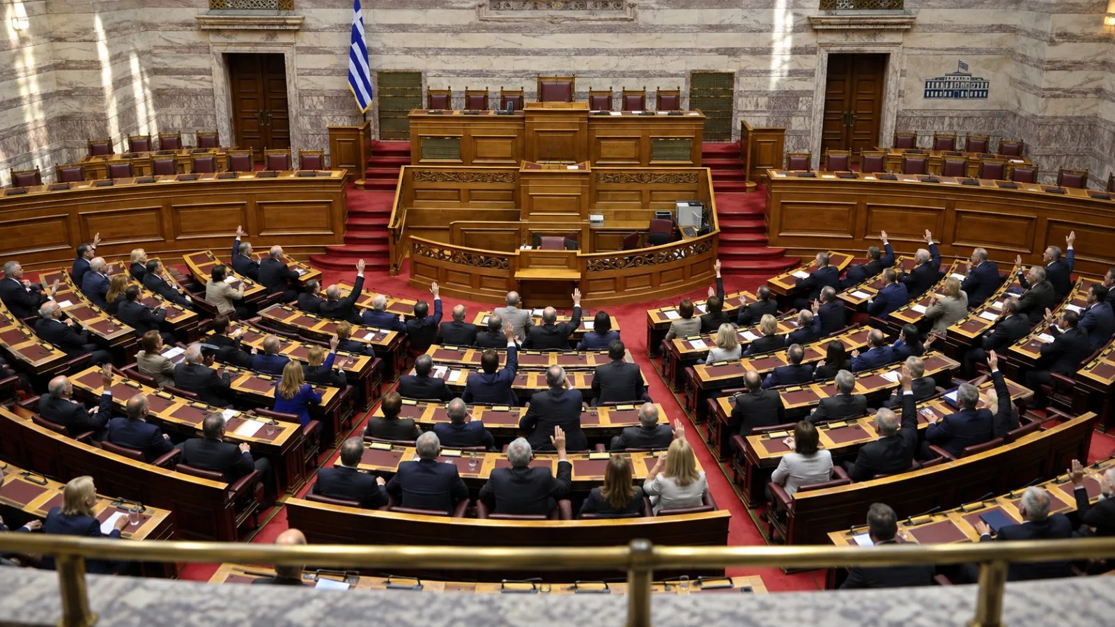 Lawmakers vote in the chamber of the Hellenic Parliament in Athens. / EconoTimes.ai