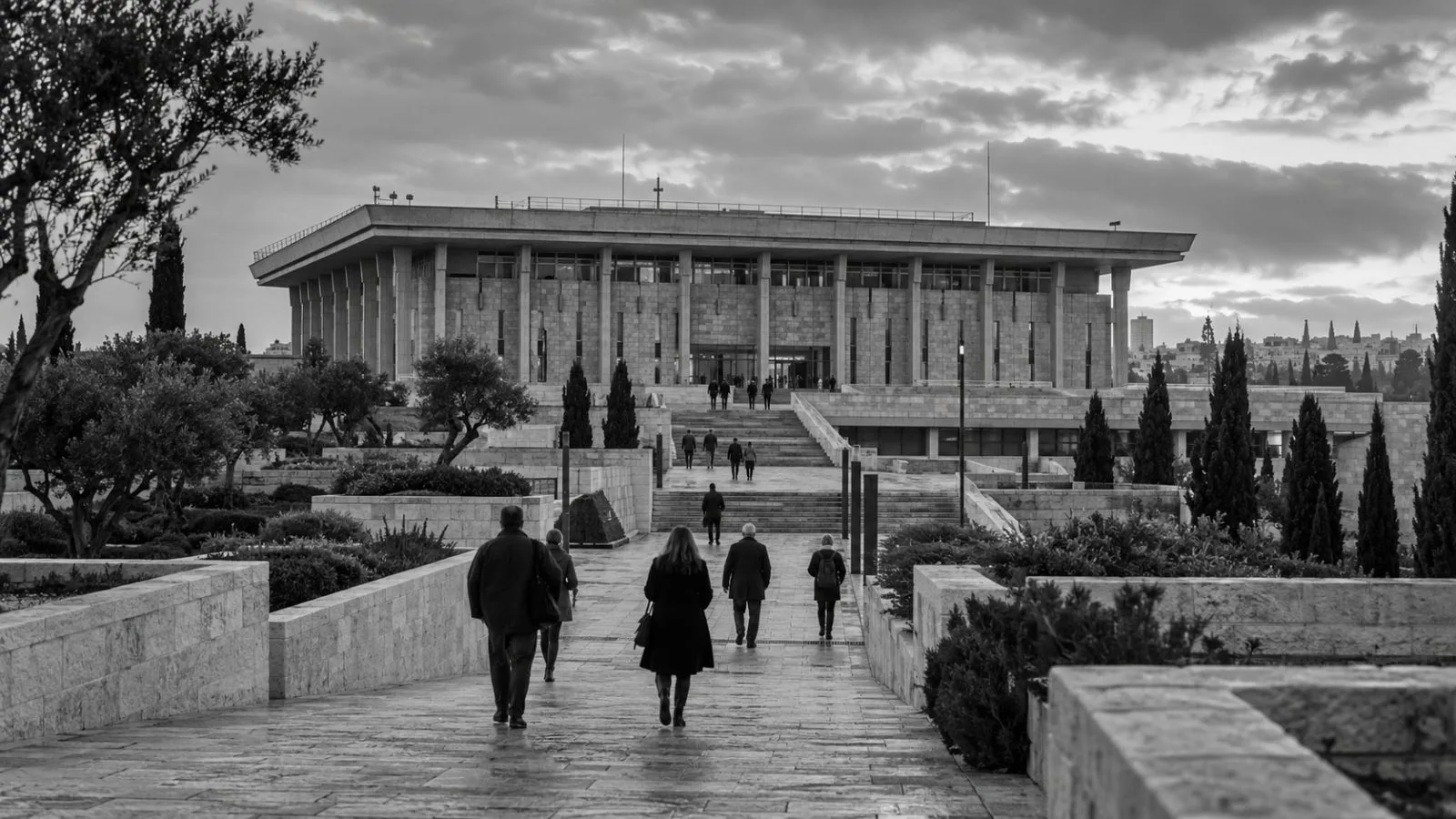 Passersby approach Israel's Knesset in Jerusalem during the country's election campaign. (AI-generated image / EconoTimes)