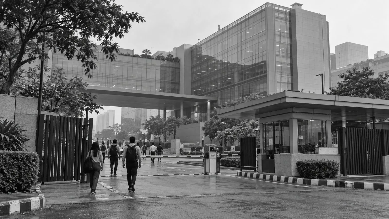 Office staff enter a corporate campus in Sector 132, Noida, India. / EconoTimes.ai (mono)