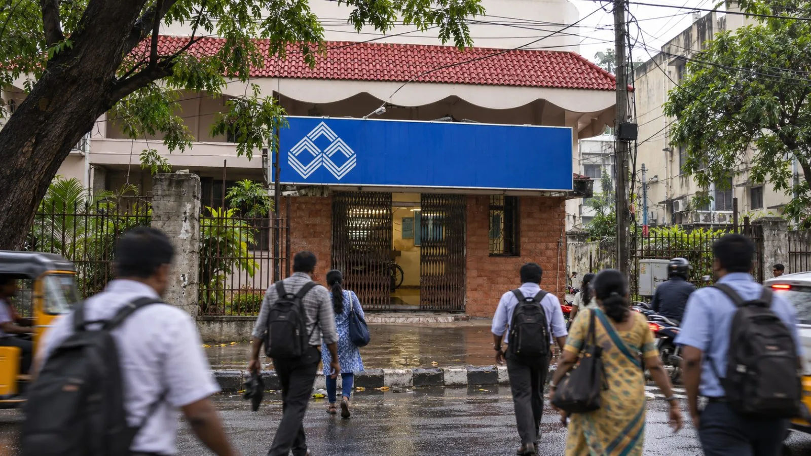 Customers pass the Indian Overseas Bank central office on Anna Salai in Chennai, India. / EconoTimes.ai