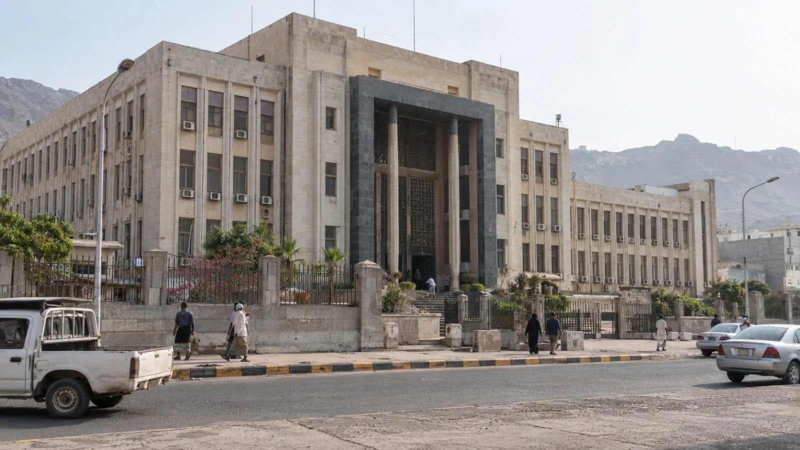 Pedestrians pass the Central Bank of Yemen headquarters in Aden, Yemen. (AI-generated image / EconoTimes)