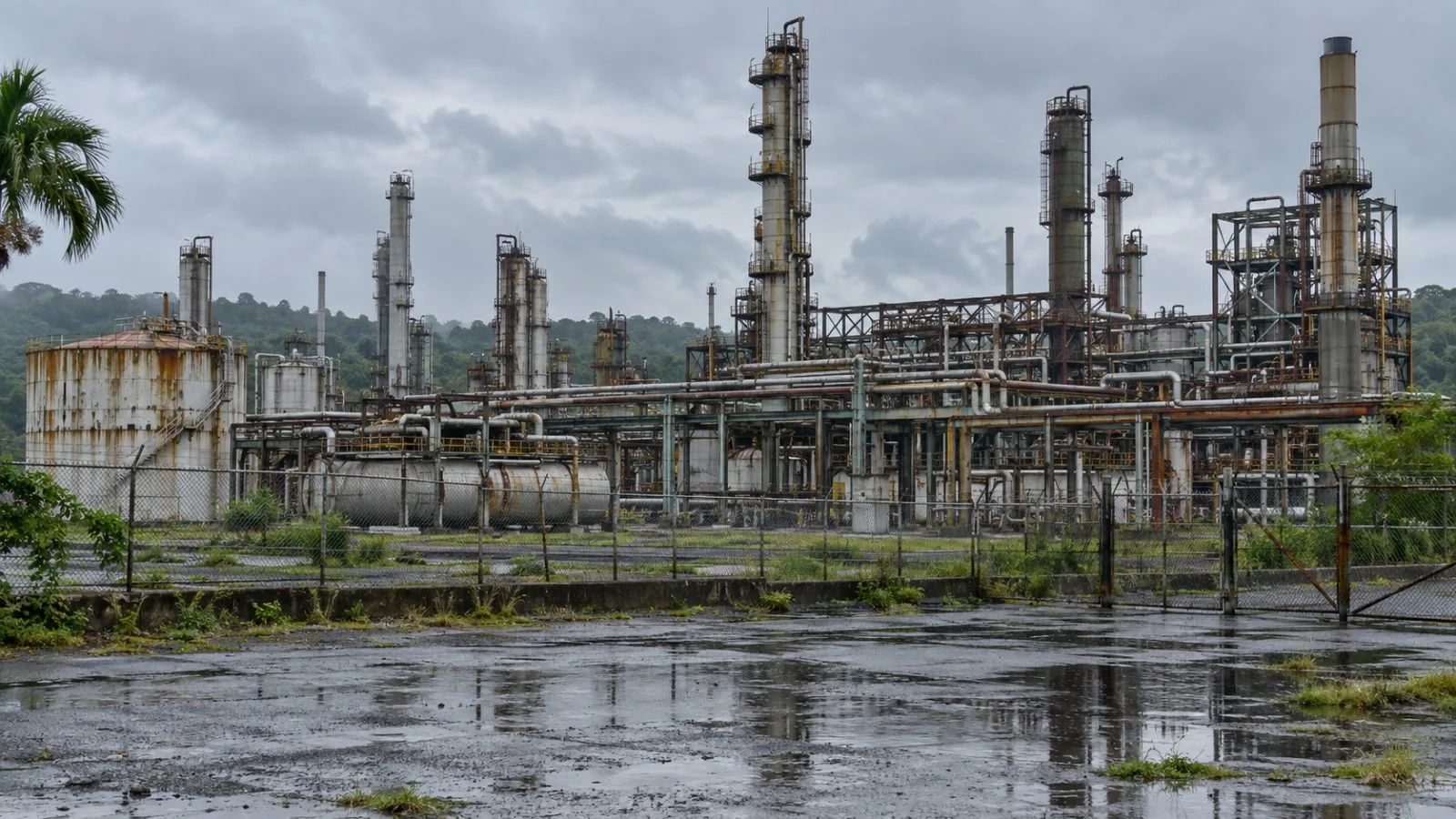 Pipework and storage tanks stand at the shuttered Guaracara refinery in Pointe-a-Pierre, Trinidad. (AI-generated image / EconoTimes)