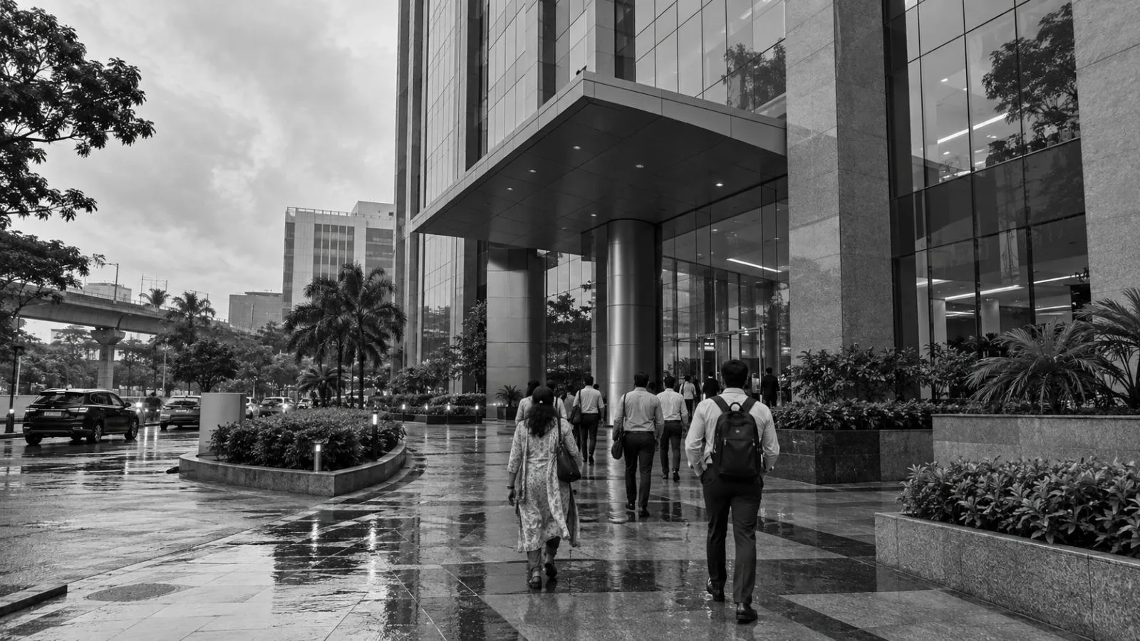 Office workers enter a commercial tower in Guindy, Chennai, India, after rain. (AI-generated image / EconoTimes)
