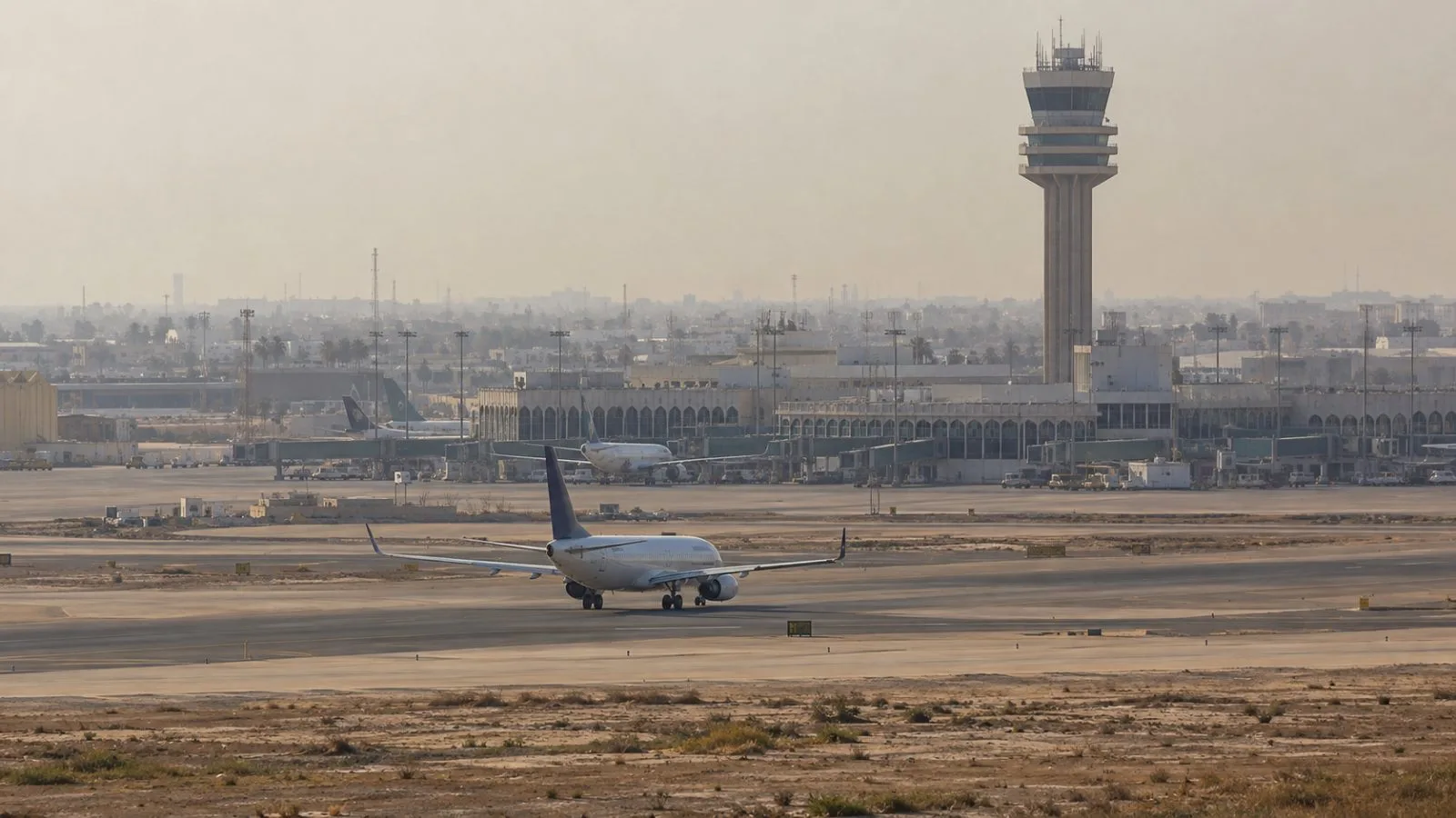 An air traffic control tower rises over the runway at Baghdad International Airport in Iraq (AI-generated image / EconoTimes)