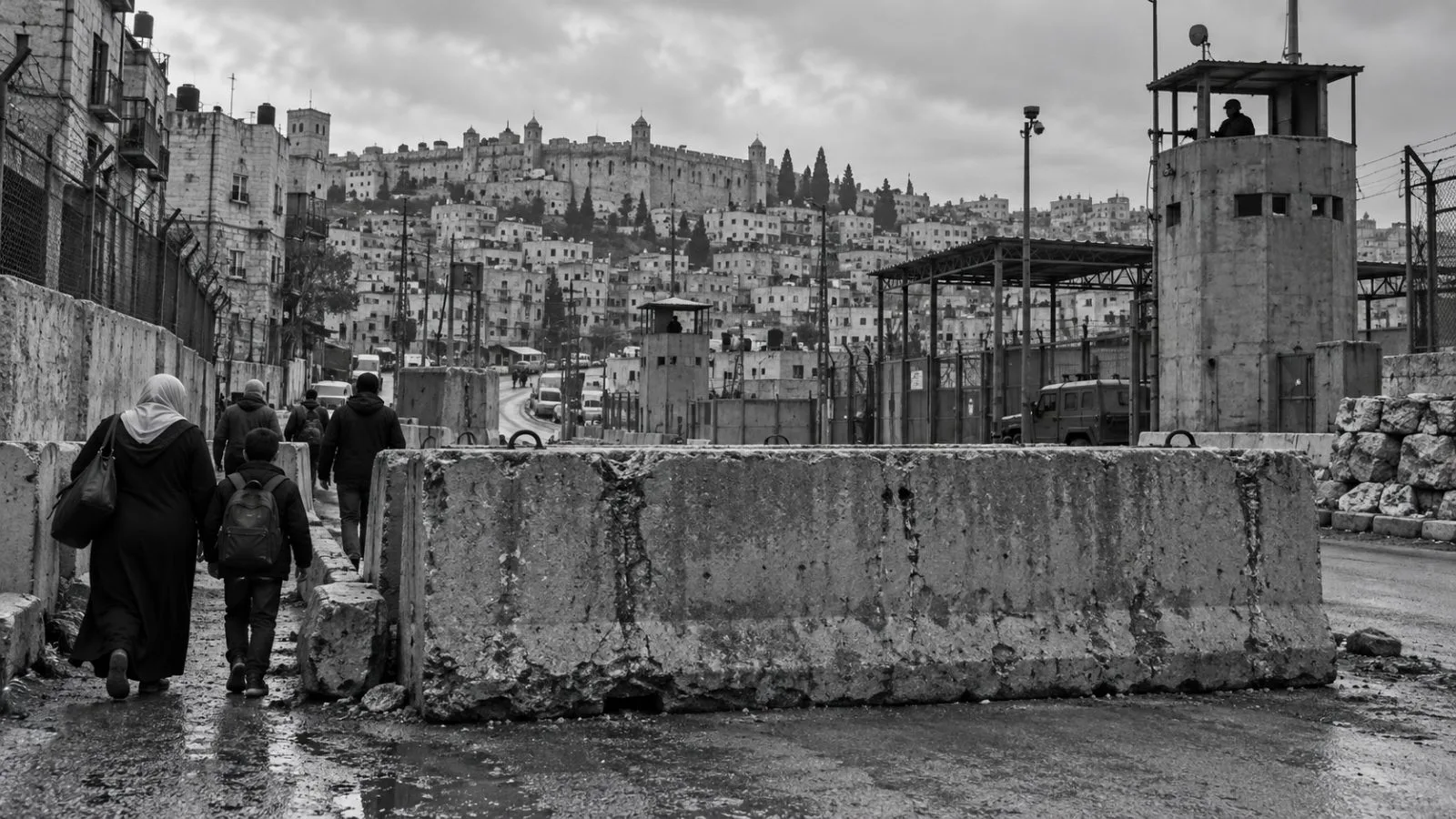 Residents cross a military gate on foot as traffic remains blocked in Hebron, West Bank. (AI-generated image / EconoTimes)