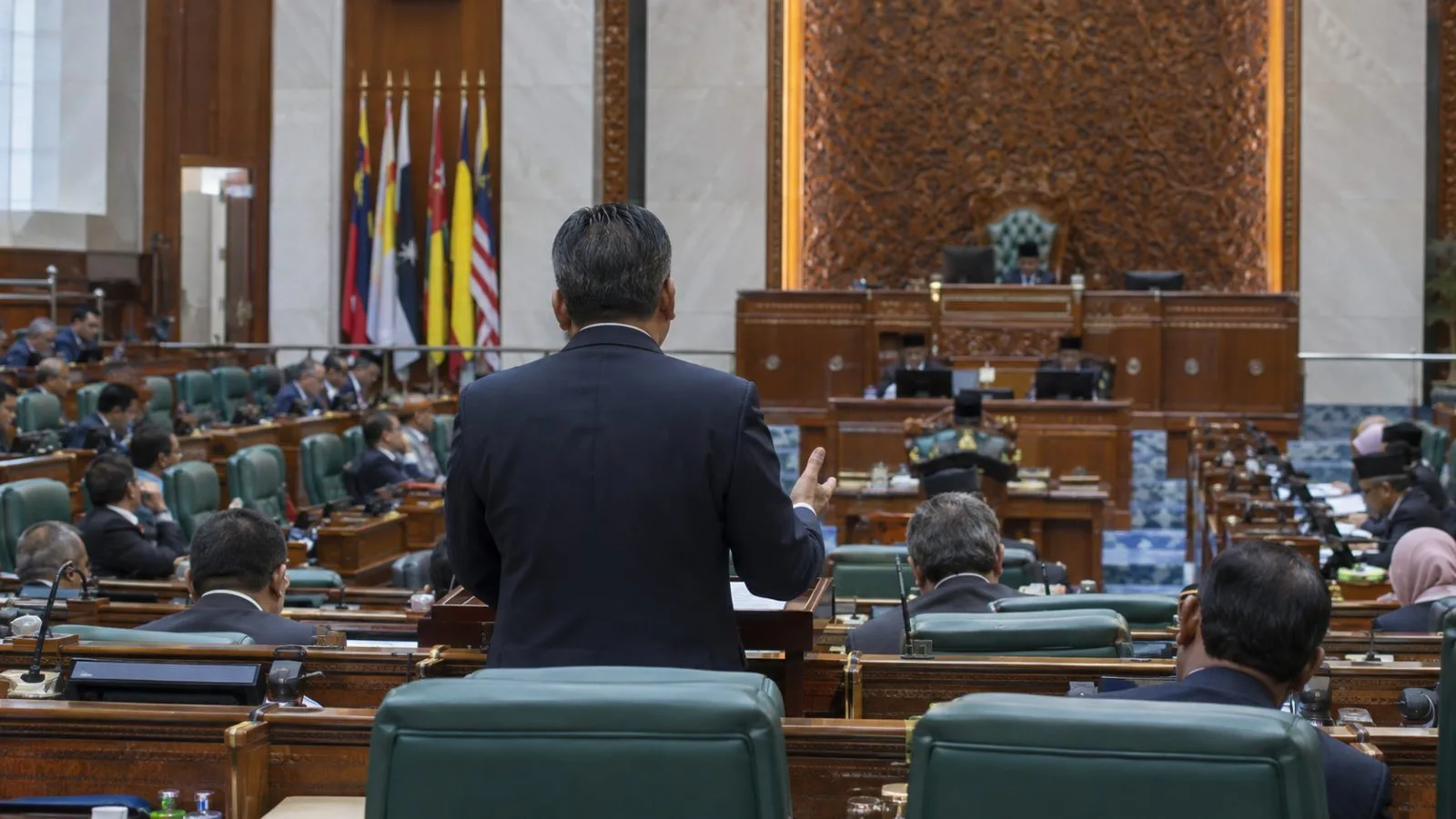 A speaker addresses lawmakers in the Dewan Rakyat chamber in Kuala Lumpur. (AI-generated image / EconoTimes)