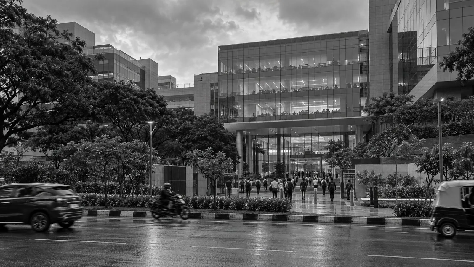 Anonymous employees enter a technology campus in Bengaluru, India, under an overcast afternoon sky. (AI-generated image / EconoTimes)