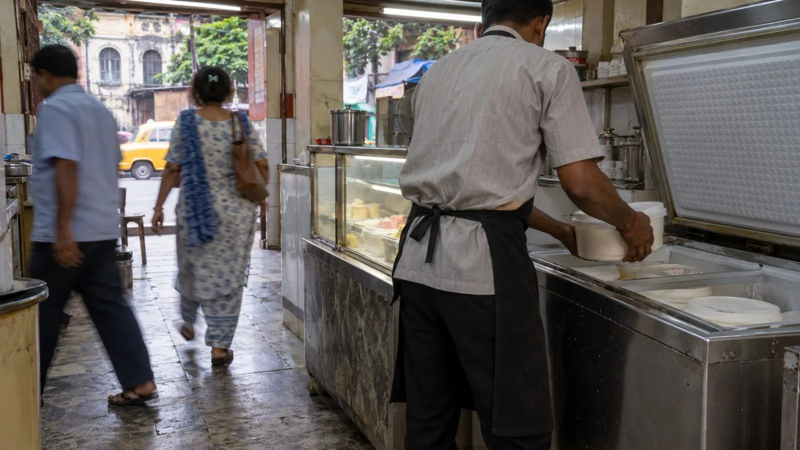 A shop worker serves ice cream at a neighborhood counter in Kolkata, India. (AI-generated image / EconoTimes)