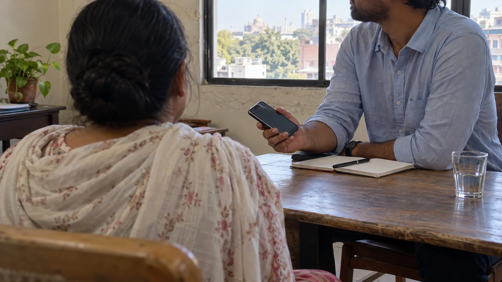 A journalist records an interview in New Delhi, India, as an interviewee listens across the table. (AI-generated image / EconoTimes)