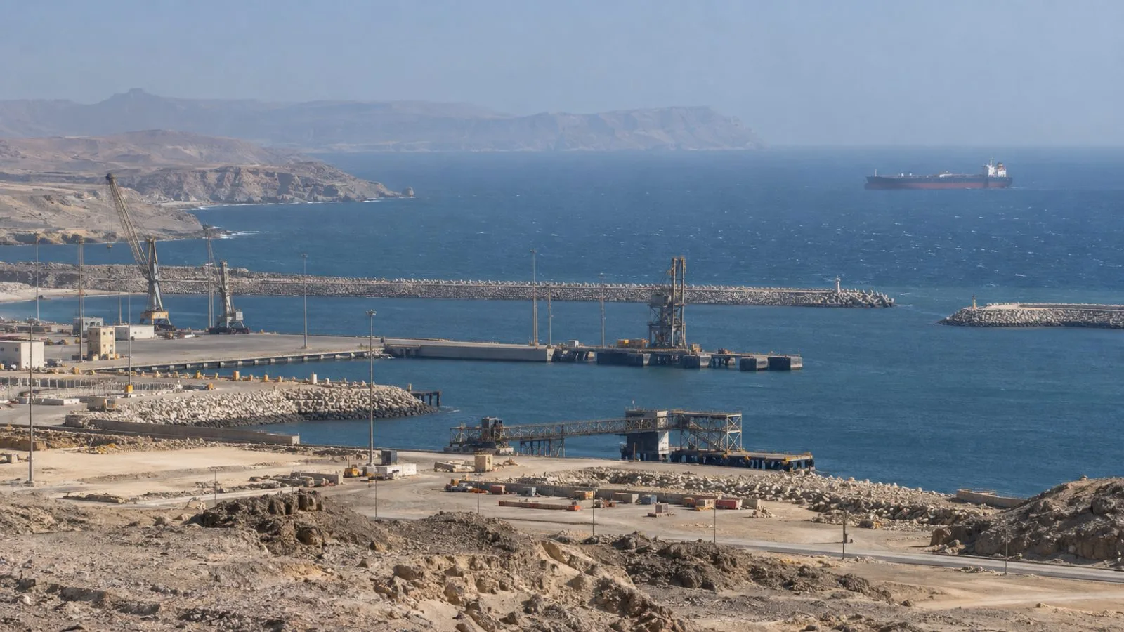 A tanker sits offshore beyond the Port of Duqm breakwater in Oman. (AI-generated image / EconoTimes)