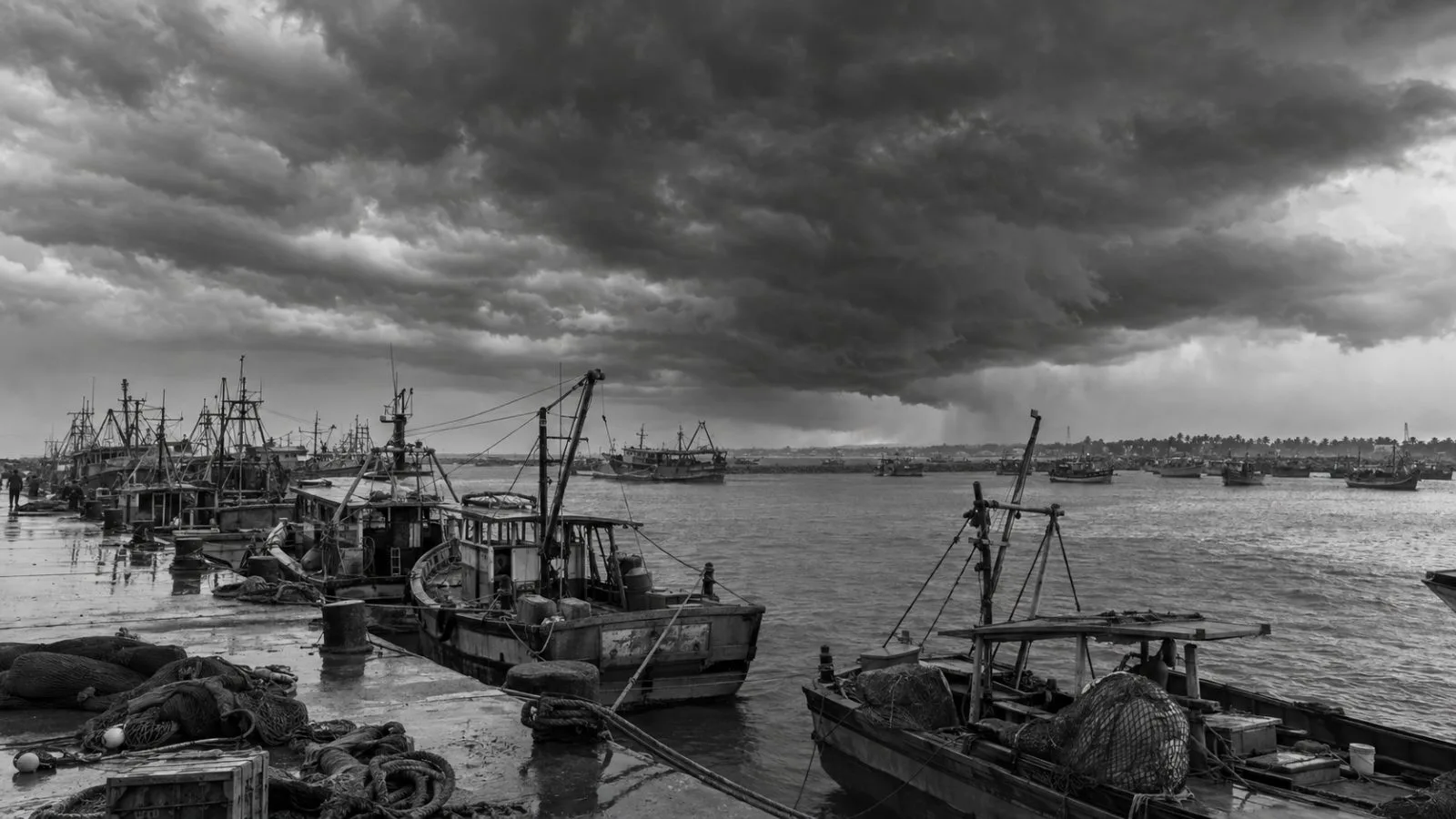 Fishing boats sit moored under heavy clouds at Kakinada harbor in Andhra Pradesh. (AI-generated image / EconoTimes)