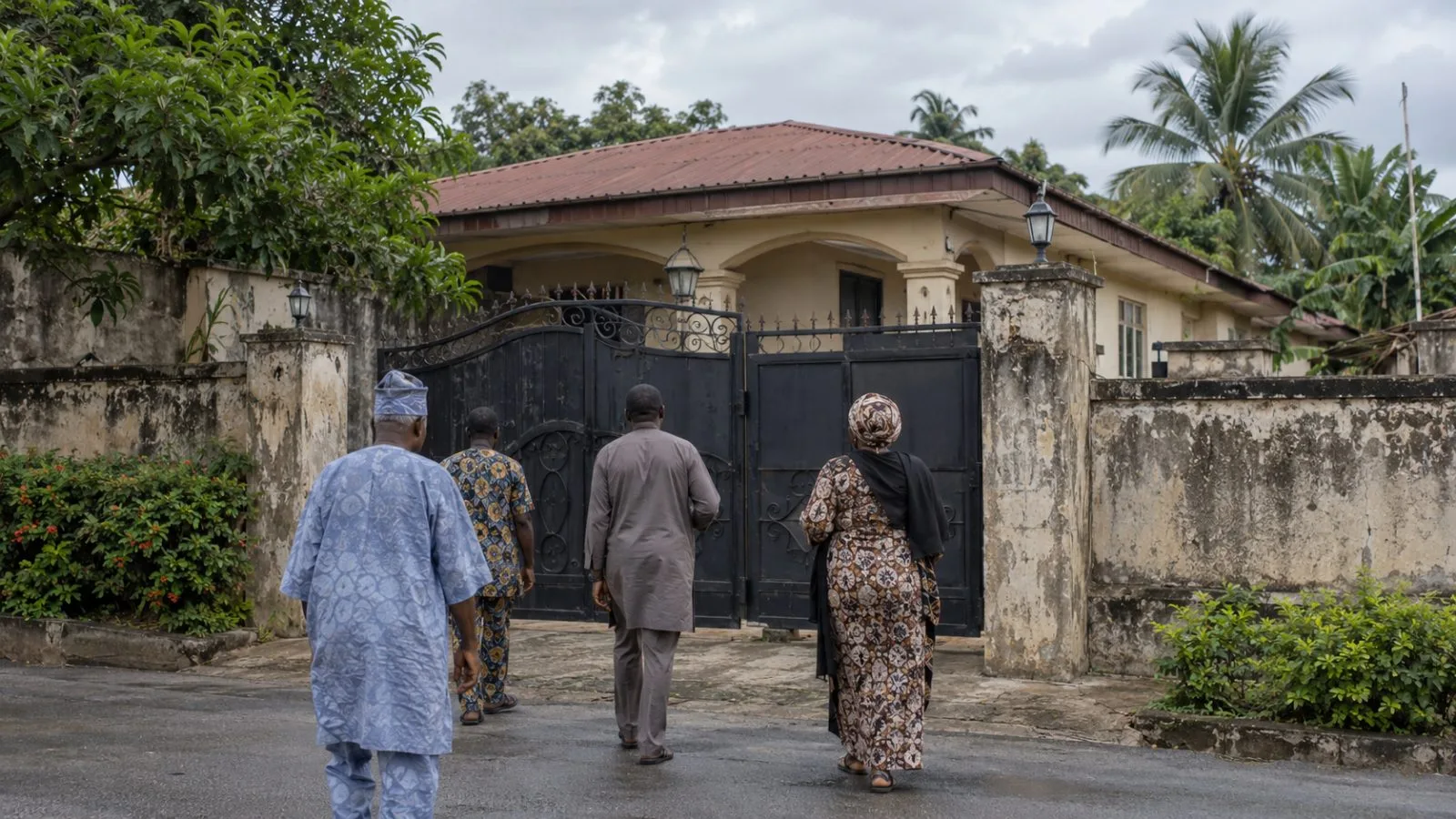 Visitors approach a residence gate in Akure, Nigeria, under an overcast sky. (AI-generated image / EconoTimes)