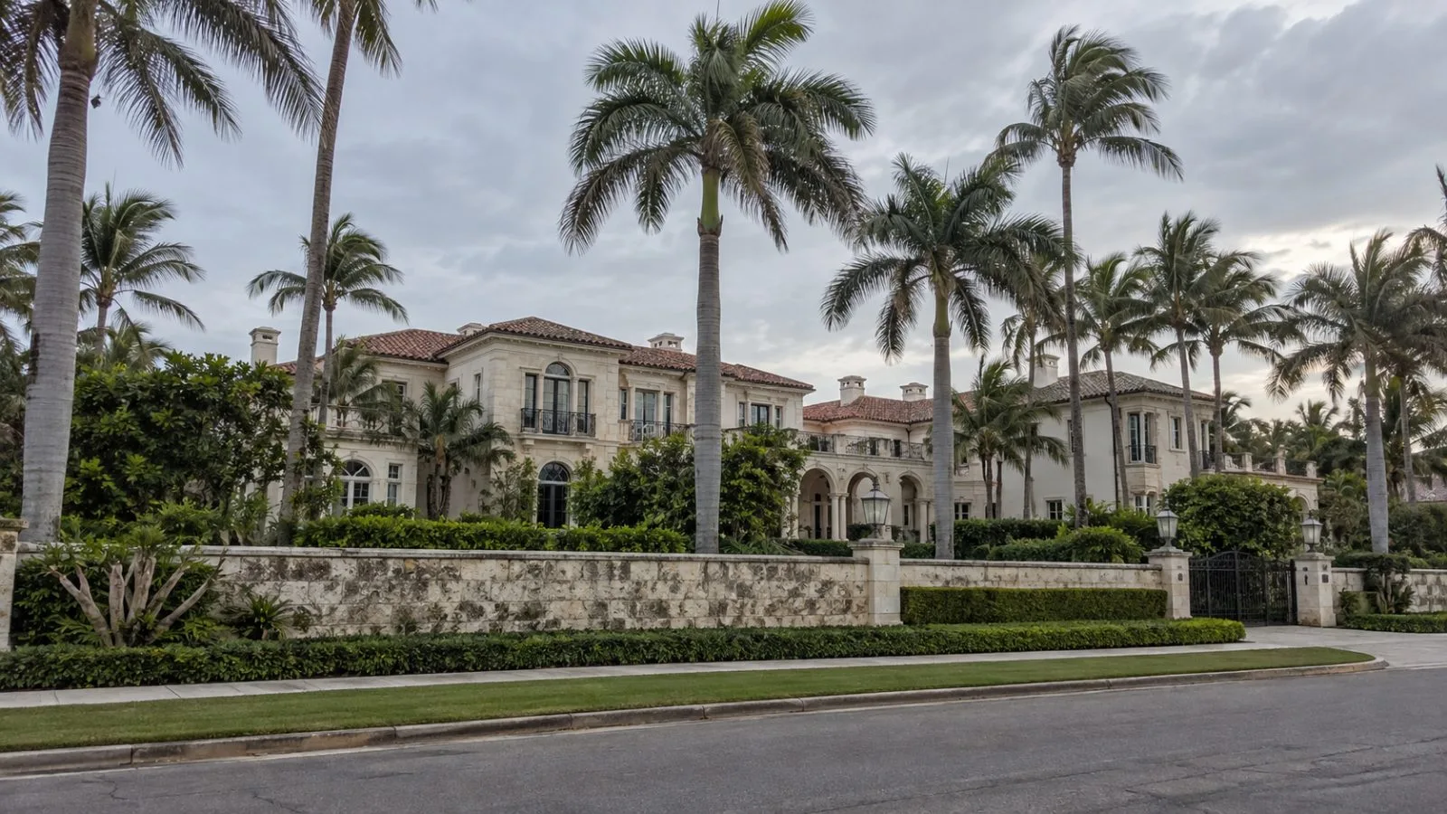 An oceanfront mansion stands behind palms and a stone wall in Palm Beach, Florida (AI-generated image / EconoTimes)