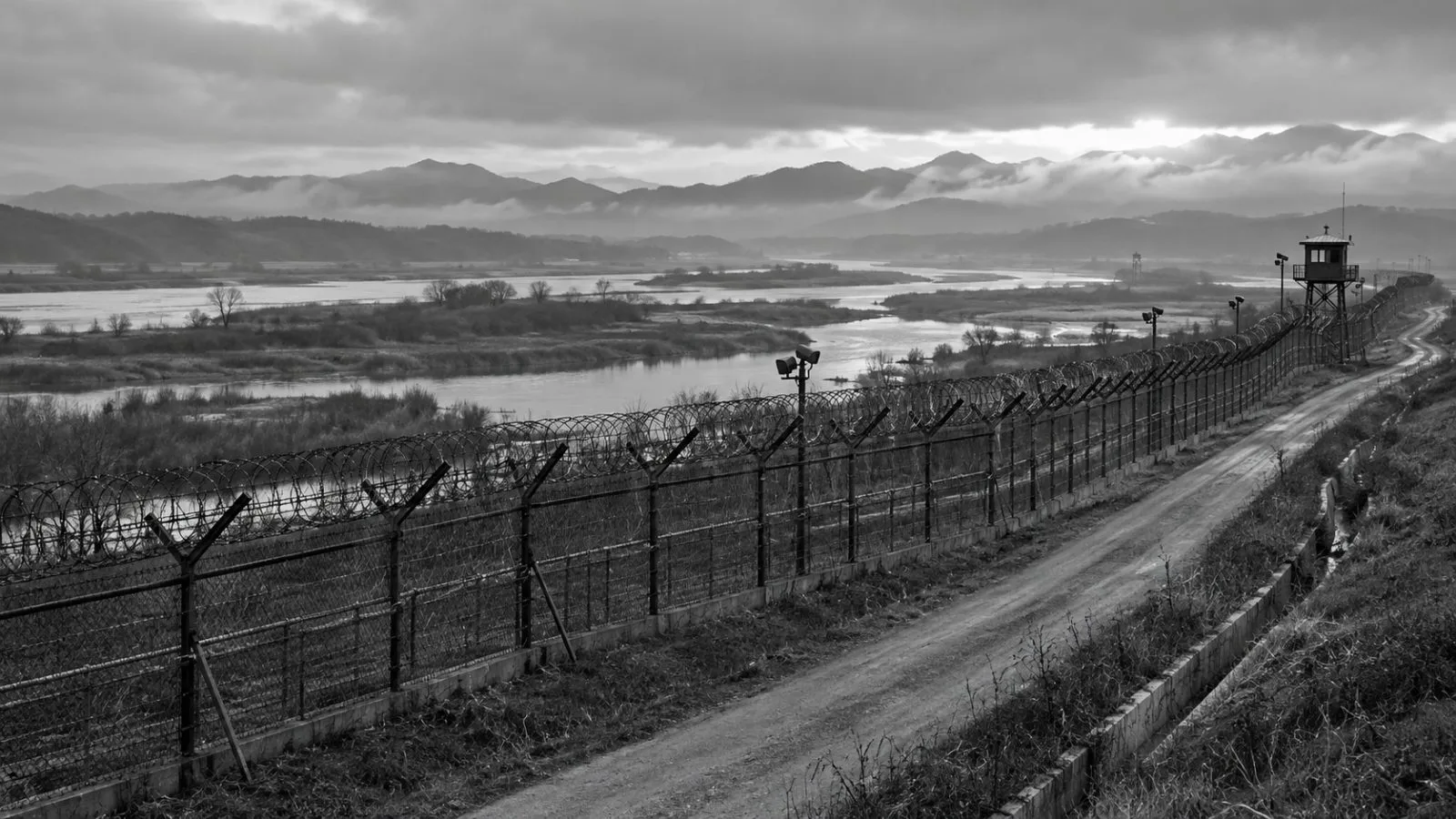 Barbed-wire fencing follows a patrol road near the western DMZ in Paju, South Korea. (AI-generated image / EconoTimes)